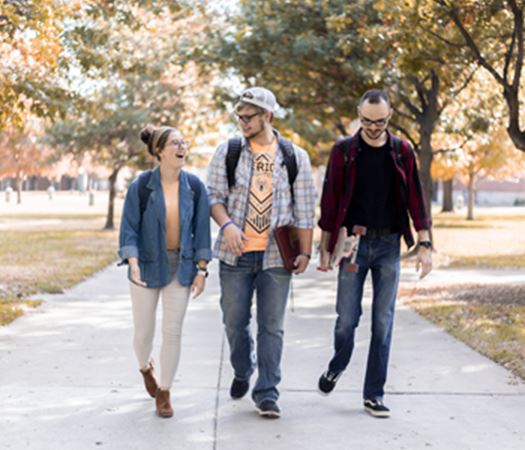 Students walking on a sidewalk laughing
